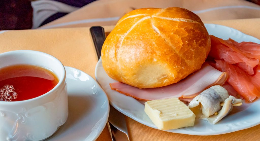 clásico desayuno aleman con pan, carnes frías, queso y té negro